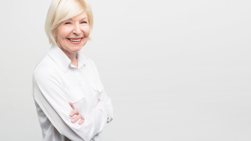 Jakie korzyści może przynieść seniorom neuroterapia? NA zdjęciu szczęśliwa, uśmiechnięta starsza kobieta w koszuli.